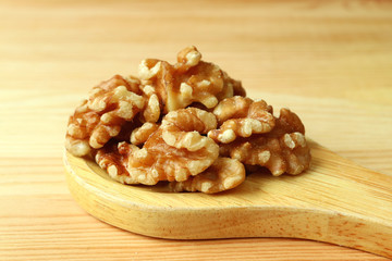 Heap of Walnut Kernels on a Wooden Spoon on Wooden Table with Copy Space