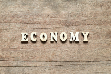 Letter block in word economy on wood background