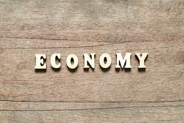 Naklejka premium Letter block in word economy on wood background