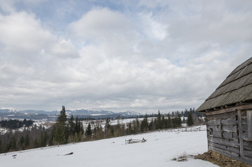 Fototapeta premium old decrepit wooden building in snow-covered mountains.