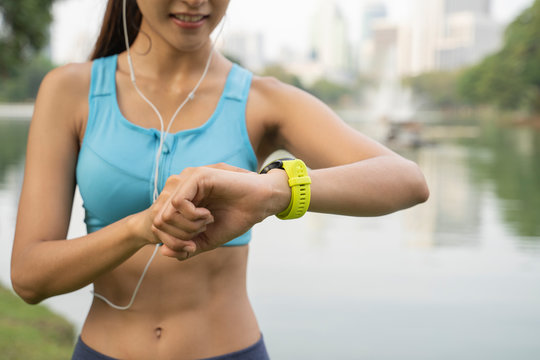Close Up image of sporty girl measuring her pulse and looking at her smartwatch, Active lifestyle and exercise concept.