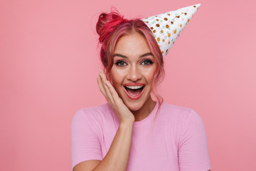 Portrait of happy woman with colorful hairstyle wearing party cone laughing