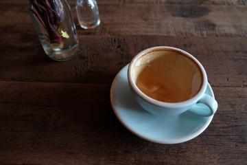 Cappuccino or latte with frothy foam, blue coffee cup top on wooden coffee shop background