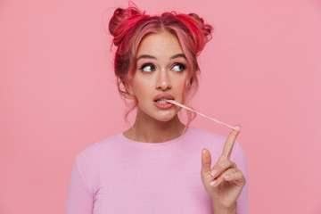 Portrait of stylish young woman with colored hair stretching chewing gum