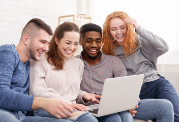 Happy students watching comedy film on laptop