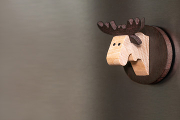 wooden moose head traditional magnet on a steel background