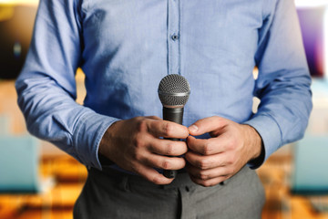Young talking man holding microphone