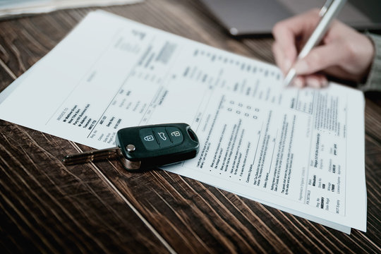 Man Signing Car Insurance Document Or Lease Paper