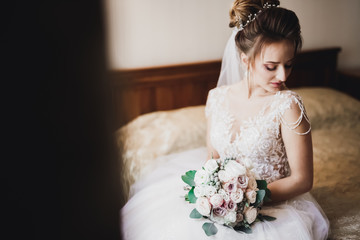 Portrait of beautiful bride with fashion veil at wedding morning