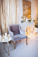 warm cozy beautiful modern design of the room in delicate light colors decorated with Christmas tree and decorative elements fireplace 