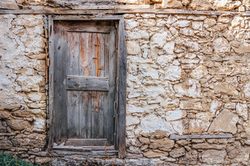 Fototapeta na wymiar Old ruined building and brown vintage wooden door