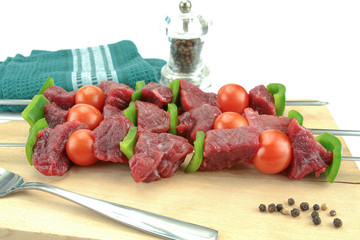 skewers of beef, pepper and raw tomato on a white background