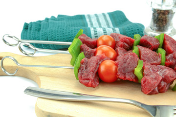 skewers of beef, pepper and raw tomato on a white background