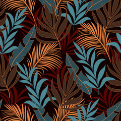 Abstract seamless tropical pattern with bright yellow and blue plants and leaves on a dark background. Beautiful seamless vector floral pattern. Exotic jungle wallpaper. Exotic plants. 