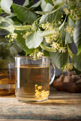 Linden tea and flowers on wooden table.