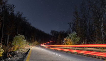 Traces of car headlights on a night road