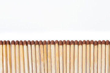 wooden matches lie in a row close up on a white background top view