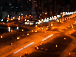 Obraz premium Blurred lights of night city and motion traffic on a highway.