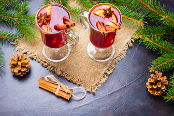 Mulled wine in glass mug with spices. Glasses of mulled wine with cinnamon, anise and fir tree branches. Winter Christmas drink. Top view