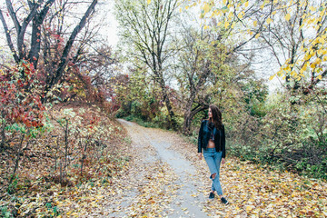 Obraz premium Girl walks in the autumn park