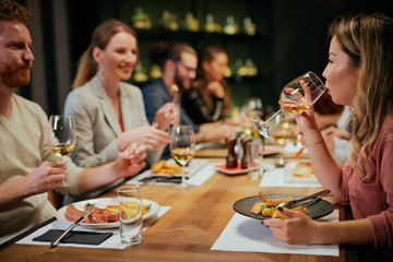 Best friends sitting in restaurant for dinner, drinking wine and chatting.