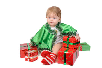 Little girl in Santa hat and green tree suit with New Year 's gifts on white.