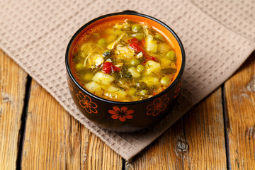 Plate with vegetable soup with chicken. Plate with soup and croutons on a wooden background. Healthy eating concept.