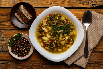 Plate with vegetable soup with chicken. Plate with soup and croutons on a wooden background. Healthy eating concept.
