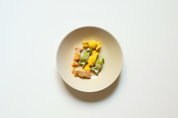 OLYMPUS DIGITAL CAMERAStuffed Pasta with caramelle shape served in a cream bowl over a white background top view