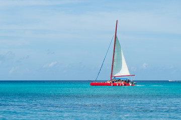 Caribbean vacations: red catamaran sailing in azure sea