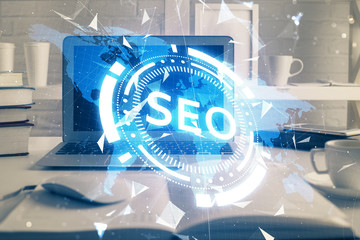 Multi exposure of table with computer and seo drawing hologram. Search optimization concept.