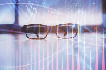 Financial graph hologram with glasses on the table background. Concept of business. Double exposure.