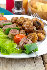 grilled potatoes and beef skewer on a plate