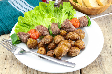 grilled potatoes and beef skewer on a plate