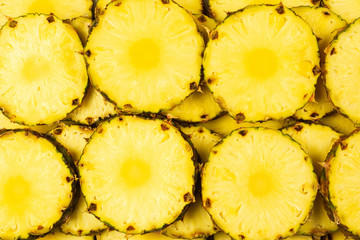 Pineapple juicy yellow slices background. Top view.