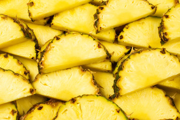 Pineapple juicy yellow slices background. Top view.