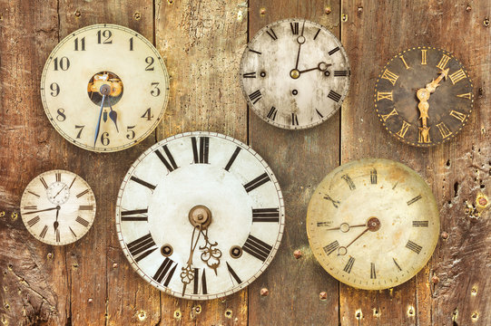 Vintage clocks hanging on an old weathered wooden wall