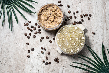 Organic homemade coffee scrub with sugar and and natural brush on rustic marble table. Skin care concept.