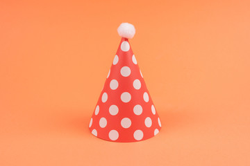 Colorful birthday caps on orange background.