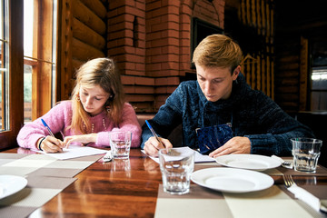 man and woman sign documents at a table in a cafe