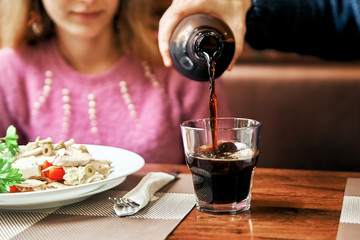 man pours a girl a glass of drink. boyfriend caring for a girl