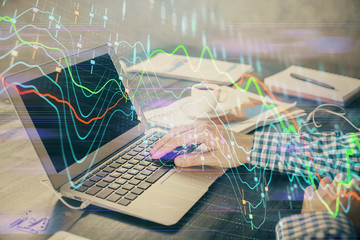 Double exposure of forex chart with man working on computer on background. Concept of market analysis.