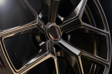 cool black aluminum die-cast car wheel on dark background, lightweight forged alloy wheels....