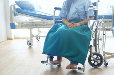 Patient sit alone on wheelchair with background sunny light in hospital recovery room feeling hope...