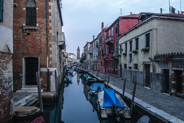 Fototapeta na wymiar Narrow canal in Venice under a cloudy sky