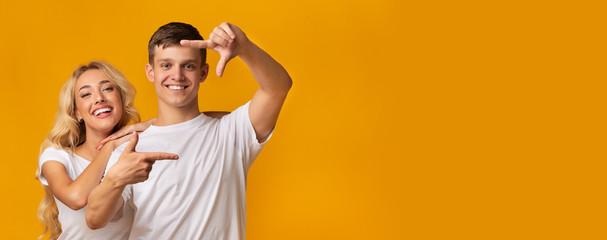 Couple making frame with hands, taking picture with imaginary camera