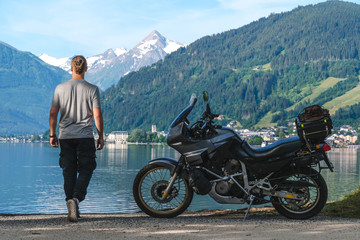 Back view biker standing with traveler motorcycle. Vacation and hobby concept, adventure on two...