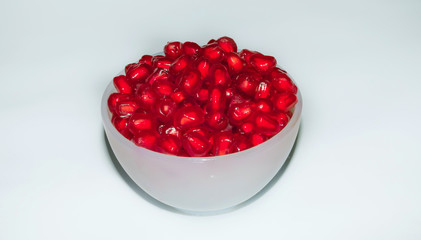 close up of fresh tasty red pomegranate seeds in a white cup