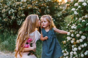 Fototapeta premium two qute sisters with peonies. Concept of happy family and love between sisters