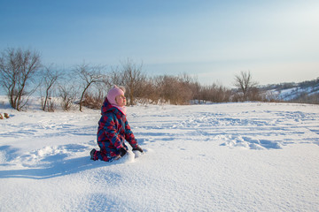 Cheerful girl throws snow on a sunny winter day. Active games with snow. The winter vacation.